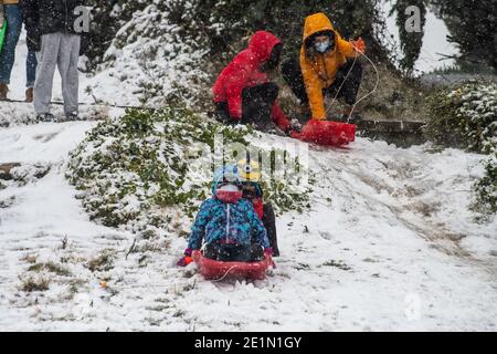Madrid, Spain. 08th Jan, 2021. Kids with sleds as snow falls in a park of Madrid. A warning has been issued across the country due to storm 'Filomena' that has caused a big drop in temperatures and snowfalls throughout Spain. Credit: Marcos del Mazo/Alamy Live News Stock Photo