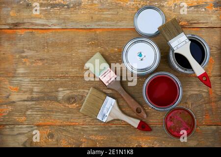 Paint cans and brushes on the old wooden background. Concept of house renovation Stock Photo