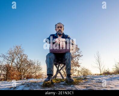 Front view of Seated Figure by Sean Henry. Large scale sculpture in a snow covered Yorkshire Scuplture Park. Stock Photo