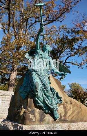 A weathered, patina green bronze statue of a trumpeting angel on the grave of Nathan and Isabel Hill Sargent. At Arlington National Cemetery. Stock Photo