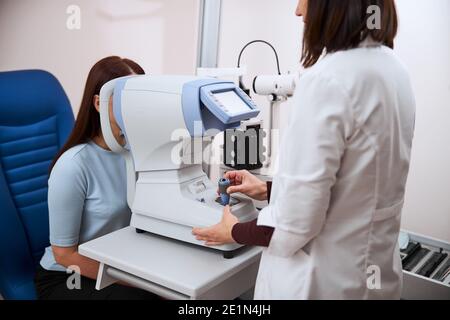 Oculist checking the woman sight on an appliance Stock Photo