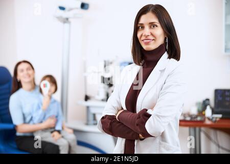 Satisfied doctor in a white coat looking proudly at camera Stock Photo