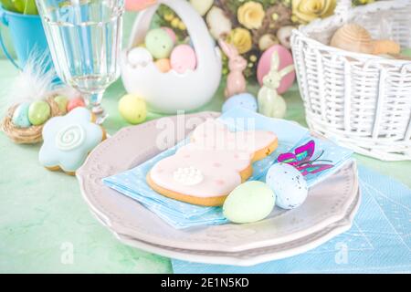 Festive Easter table setting with traditional spring flowers, Easter colorful eggs and sugar cookies. Easter greeting card background copy space Stock Photo