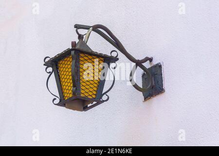 Antique street lamp on wall of building. Forged iron elements lantern. Selective focus, fog view. Stock Photo