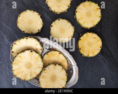 Sliced and chopped pineapple on a dark background Stock Photo