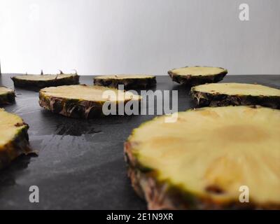 Sliced and chopped pineapple on a dark background Stock Photo