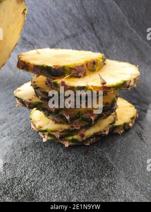 Sliced and chopped pineapple on a dark background Stock Photo