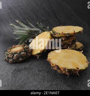 Sliced and chopped pineapple on a dark background Stock Photo