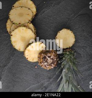 Sliced and chopped pineapple on a dark background Stock Photo