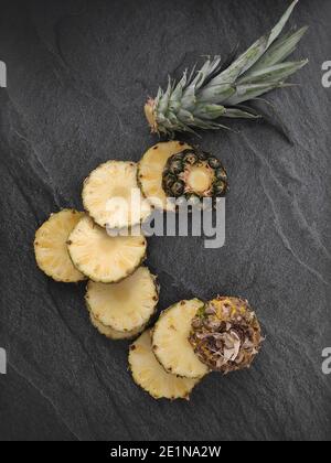 Sliced and chopped pineapple on a dark background Stock Photo