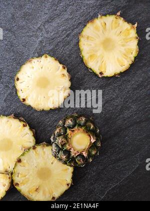 Sliced and chopped pineapple on a dark background Stock Photo