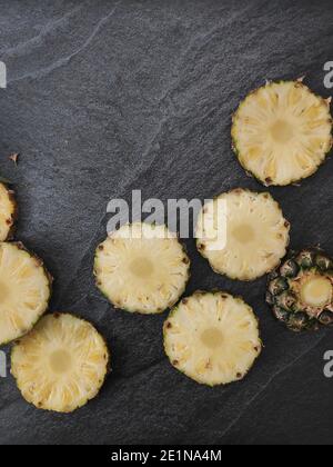 Sliced and chopped pineapple on a dark background Stock Photo