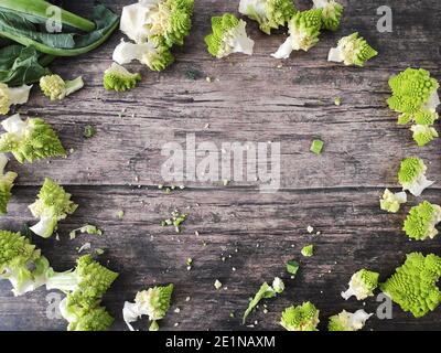 Romanesco broccoli heads scattered  on a wooden kitchen table Stock Photo