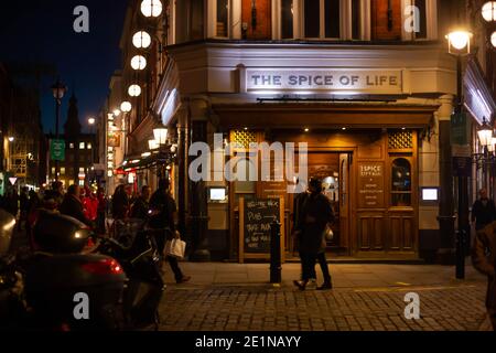 Street view of crowds of people and night scene outside The Spice of Life, London, Britain, December 2020 Stock Photo