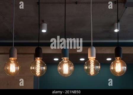 Decorative antique edison style light bulbs. Set of different vintage glowing light bulbs in loft interior Stock Photo