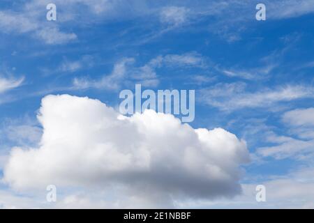 Lonely large cloud in the blue cloudy sky. This is a symbol of loneliness. Close-up. Stock Photo