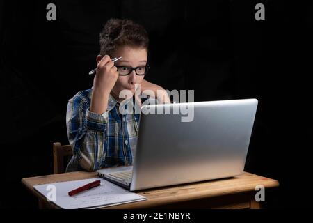 Student on laptop at home with pen Stock Photo