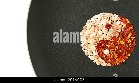 yin yang food ingredients. Himalayan salt chili pepper in red black colour on white background Stock Photo