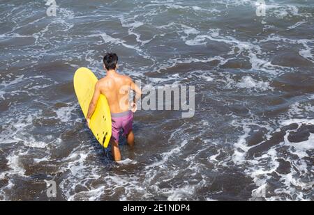 Surfer with yellow surfboard. Stock Photo