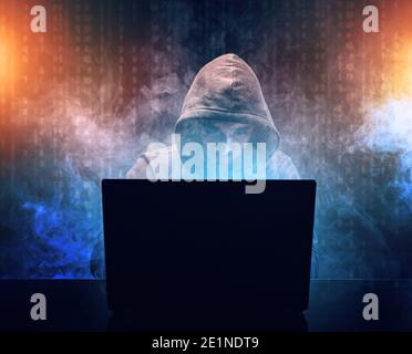 Hacker in front of his laptop. Hooded hacker cyber war concept Stock Photo