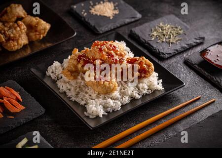 Prawns in tempura batter with sweet chilli sauce served with rice Stock Photo