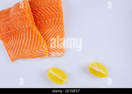Two raw salmon fillets with lemon on white background Stock Photo