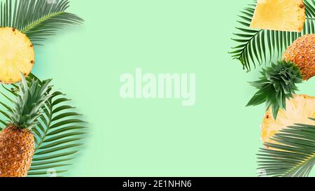 pattern with pineapple and pineapple slices and palm leaves on a green mint background. Stock Photo