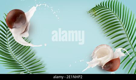 pattern with coconuts, milk splash and palm leaves on a blue background. Stock Photo