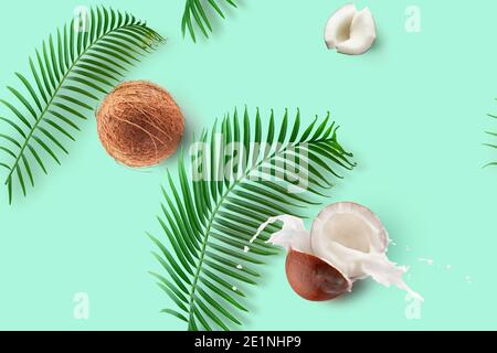 seamless pattern with coconuts, milk splash and palm leaves on a green mint background. Stock Photo