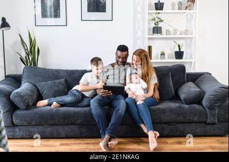 A multiracial family on the couch at home Stock Photo