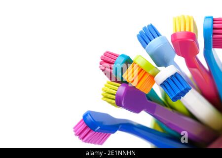Group of colorful toothbrushes in cup isolated on white background. Top view Stock Photo