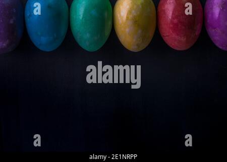 Easter multicolored eggs from stones on a dark background. Stock Photo