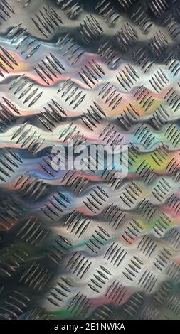 metal panel with notch and colored reflections stainless steel sheet with diamond plate pattern Stock Photo