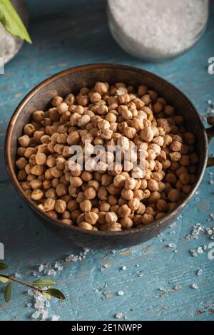 Uncooked dried chickpeas in bowl on wooden background. Stock Photo