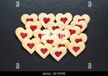 christmas cookies hearts with strawberry jam on slate table Stock Photo