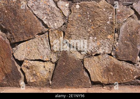 Image of a wall formed by tiled stones that protect a house from the elements Stock Photo