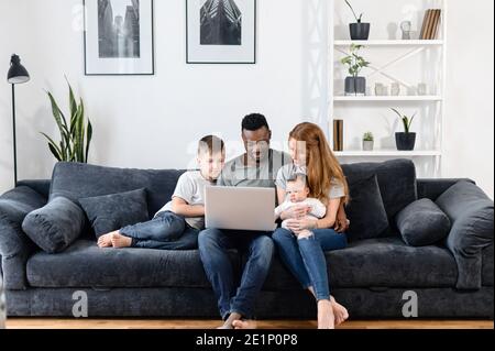 A multiracial family on the couch at home Stock Photo