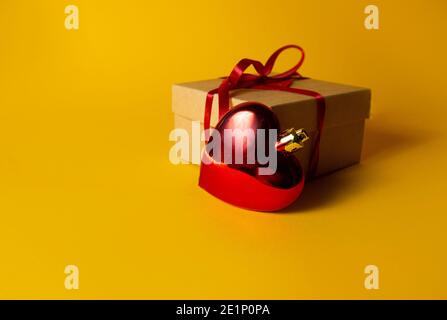 gift with red heart on yellow background Stock Photo