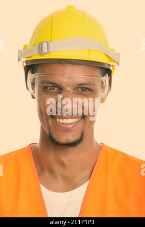 Face of happy African man construction worker smiling while wearing protective glasses Stock Photo