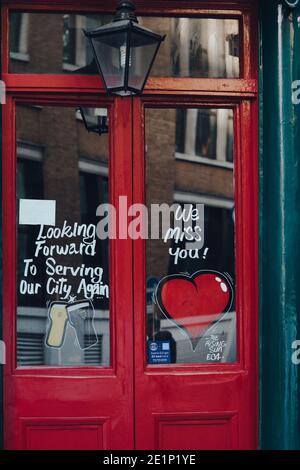 London, UK - November 19, 2020: We miss you heart signs on a door of a closed The Rising Sun pub in London. Pubs and restaurants in England are closed