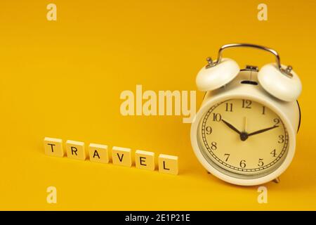 Travel composition, time to go outside with alarm clock on yellow background. High quality photo Stock Photo