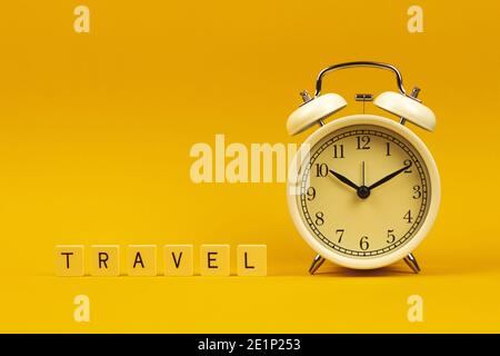 Travel composition, time to go outside with alarm clock on yellow background. High quality photo Stock Photo