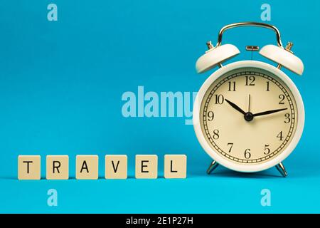 Template with word travel and alarm clock, composition on blue isolated background with copy space, photo Stock Photo