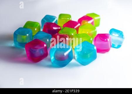 plastic cubes filled with liquid for freezing and cooling water. Icy colored cubes with shadows on white background. Close-up photo Stock Photo