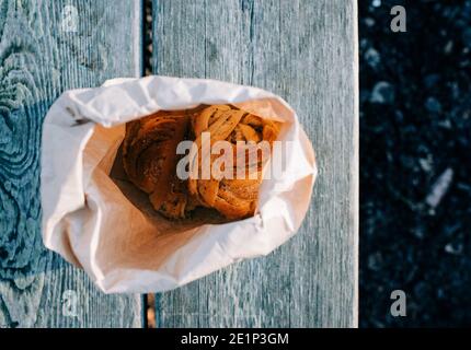 cardamon buns in a paper bag on a bench in Sweden Stock Photo
