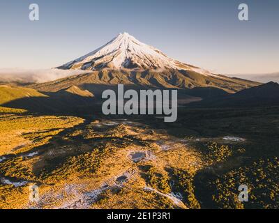 Mount Taranaki volcano after the first snowfall of the season at sunset, New Zealand. Stock Photo