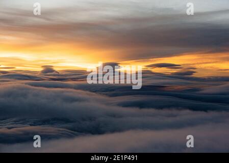 sunset over sea of clouds from the plane Stock Photo