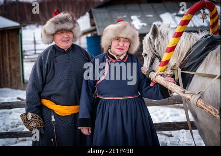 Naryn-Atsagat zone, near Oulan Oude (ulan ude), Siberia, Russia - Mars 09, 2020 : Couple of Buryats  in traditional costumes with their horse. Stock Photo