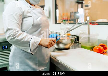 cook in her restaurant sharpening her knives Stock Photo