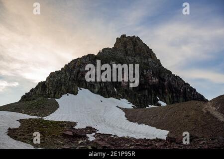 Soft White Clouds Fade Over Mount Oberlin in Glacier National Park Stock Photo